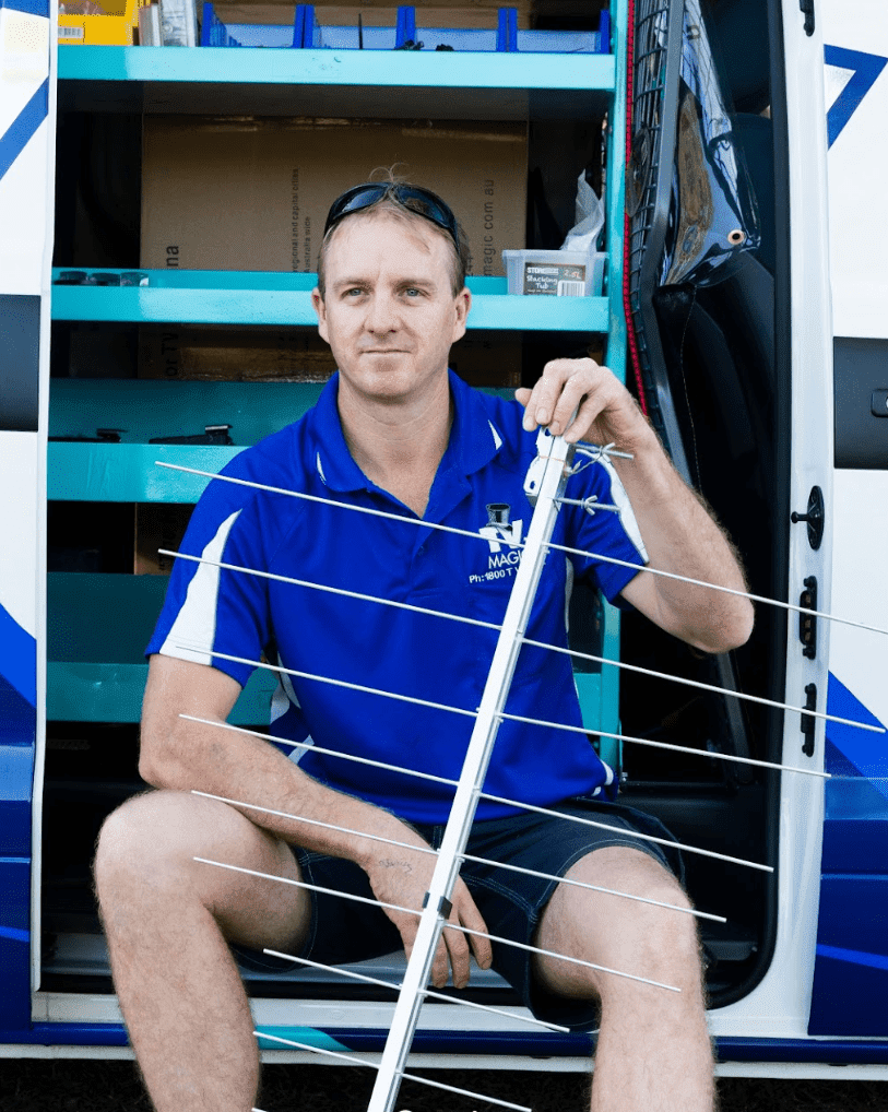 Brent from TV Magic sunshine coast in front of his work van holding an antenna